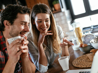 Loving couple drinking coffe in the kitchen. Happy smiling wife enjoy in the morning with her husband.