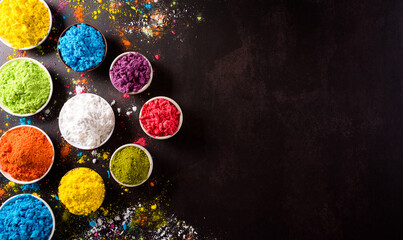 Obraz na płótnie Canvas Happy holi festival decoration.Top view of colorful holi powder on dark background with copy space for text.