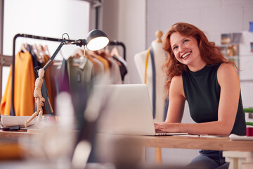 Female Student Or Business Owner Working In Fashion Using Laptop In Studio