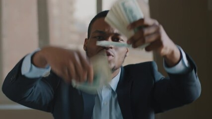 Portrait of successful afro american business man celebrating winning lottery scattering money in air throwing dollars dancing singing in office feeling happiness joy of receiving finance investment - Powered by Adobe