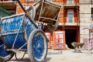 Crane is lifting industrial tipping wheelbarrow from the ground