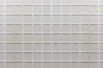Fototapeta premium Clean neat ceramic tile texture structure with embossed squares and visible bumps.