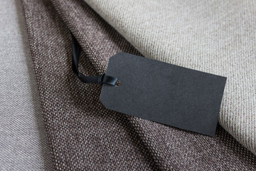 Mockup template composition of brown fabric layers and black blank empty paper price tag.