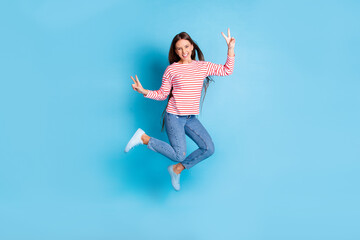 Fototapeta na wymiar Full length body size photo jumping girl showing v-sign gesture with both hands smiling isolated vivid blue color background