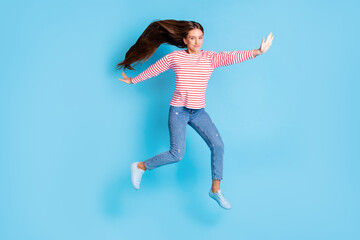 Full length body size photo girl jumping playful childish careless isolated vibrant blue color background