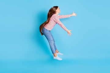 Full length body size side profile photo girl jumping flying cyclone strong wind isolated vibrant blue color background