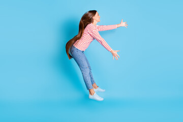 Obraz premium Full length body size side profile photo girl jumping flying cyclone strong wind isolated vibrant blue color background