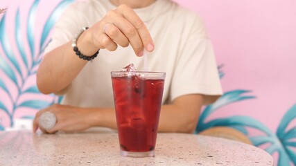 Female stirring up her berry ice tea. Refreshing drinks concept