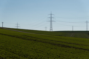 Strommasten auf grünem Feld
