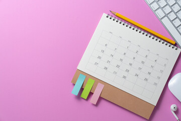 close up of calendar and accessories on the pink table background, planning for business meeting or travel planning concept