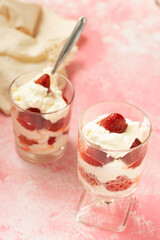 Whipped cream with strawberry on a pink background