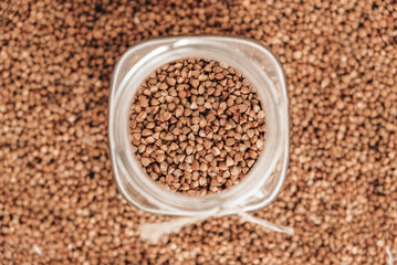 Buckwheat in a glass jar on a background of cereals. Top view. Copy, empty space for text
