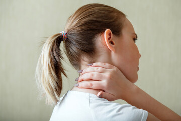 Neck shoulder pain, cervical vertebrae. Woman holds neck with pain cervical muscle spasm by hand. Disease of musculoskeletal system in young woman. Health care and medical concept.