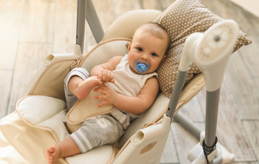 Portrait of a child in an electric cradle. Happy childhood