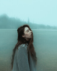 A girl walking in a foggy park