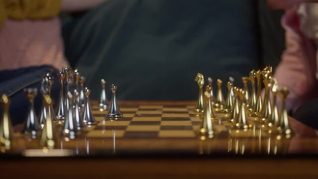 Girl and man playing chess top view. chessboard on a white background with chess pieces. Players making moves. Evning time