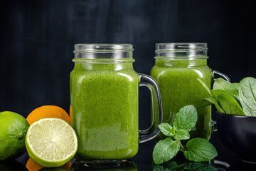 Healthy green smoothie with spinach in glass jars.