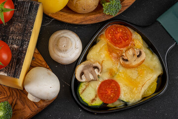 Delicious traditional Swiss melted raclette cheese on chopped boiled potatoes