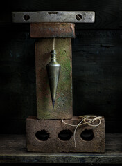 Old plumb bob and old bricks in still life