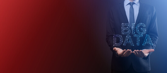 Businessman in a suit on a dark background holds the inscription BIG DATA. Storage Network Online Server Concept.Social network or business analytics representation