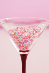 birthday cocktail concept, martini glass filled with multicolour candies