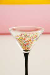 birthday cocktail concept, martini glass filled with multicolour candies