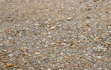 texture of colorful pebbles and pressed stones on the flat surface of the ground