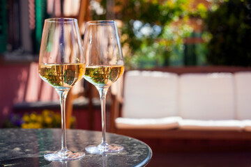 glass of chilled white wine on table over Tuscany backgound