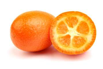 Half and a whole ripe cumquat is isolated on a white background.
