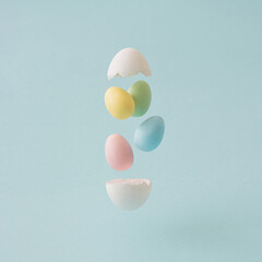 Easter flying Eggs with pastel colors on the soft blue color. Minimal concept.