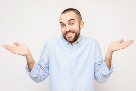 Smiling confused man shrugs, portrait, white background