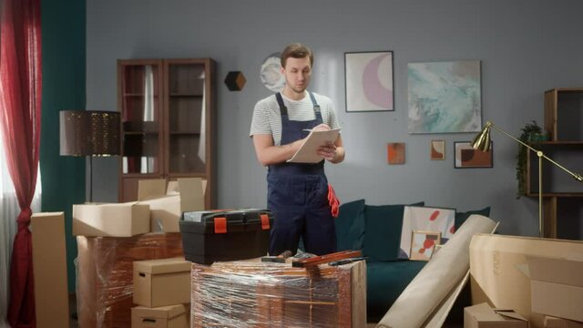 Repairman worker do apartment inspection in home and mesure room. Handyman with copybook and pan calculate walls size . Moving to new apartment or office Daylight