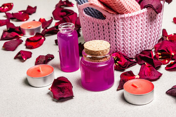Floral and spa concept with dried roses petals, fragrant candles and soft towel
