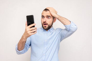 Shocked bearded man with phone, white background, copy space