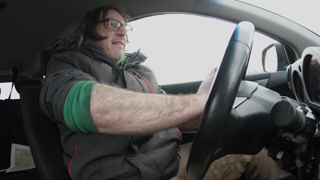 Frustrated an aggressive man in traffic having a road rage incident. He is honking and screaming at other drivers.