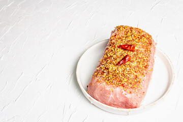 Pork fillet for grilling, baking, or frying with flakes spices in ceramic plate