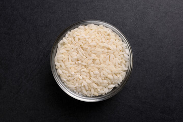 Short grain pilaf polau risotto rice in glass bowl on black background
