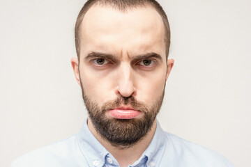 Frustrated bearded man, man pouted his lips out of resentment, sad face of the bearded man, close-up