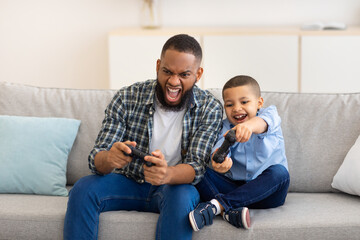 African Dad And Son Bonding Playing Video Game At Home © Prostock-studio