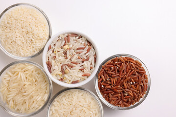 Long grain basmati medium grain jasmine short grain pilaf polau risotto brown low glycaemic index gi rice in small glass bowl on white background copy text space top flat lay view
