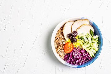 Buddha Bowl with buckwheat, baked lean pork, red cabbage, cucumber, tomato, olives, flax seeds