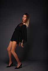 High fashion portrait of an elegant woman in a short black dress.