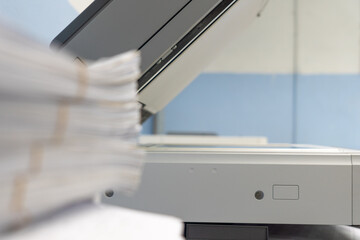 Stack of documents waiting to copy or scan convert to digital data. Blurred of woman is copying or...