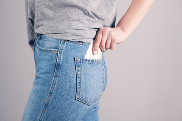girl hand putting money in jeans pocket