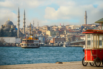 Naklejka premium View of the Bosphorus and the old town on a sunny day. An old traditional merchant cart at the wharf. Istanbul. Turkey 