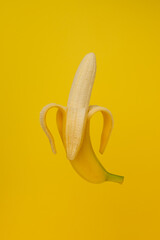 Peeled banana on a yellow background.