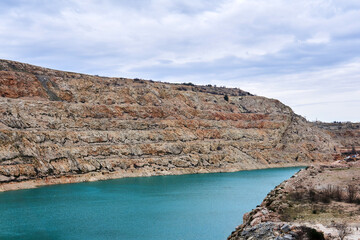 section of an old limestone quarry with a blue lake at the bottom