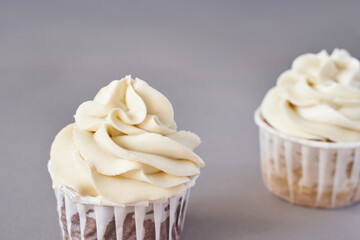 Milky cream cupcake. Birthday sweet bakery. Cookies. Yummy buttercream dessert. Wedding party food. Grey background. Holiday recipe. Anniversary gourmet. Two pieces