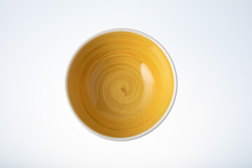 Empty white bowl with hand painted yellow inside. Isolated on white background