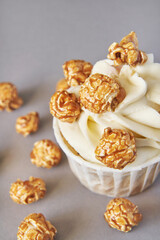Milky cream cupcake. Birthday sweet bakery. Cookies. Yummy buttercream dessert. Wedding party food. Grey background. Holiday recipe. Anniversary gourmet. One pieces. Caramel popcorn